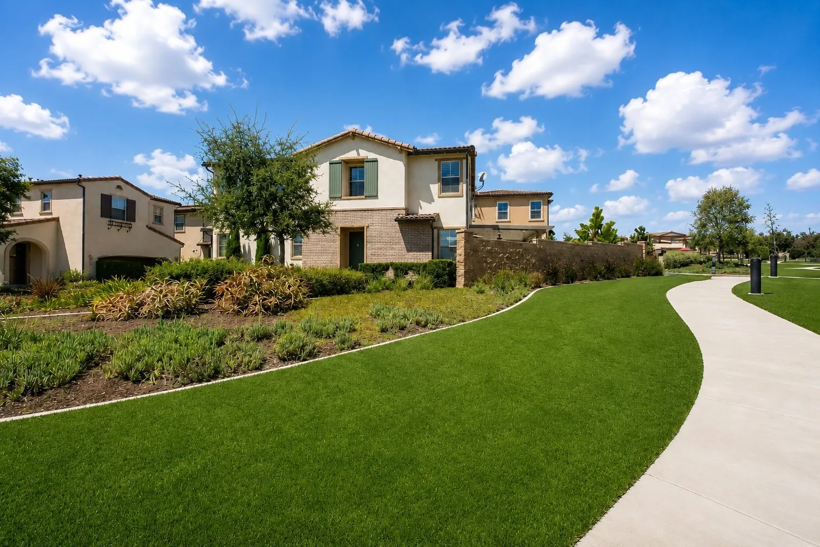 Mediterranean-style homes above a landscaped greenbelt and walking path