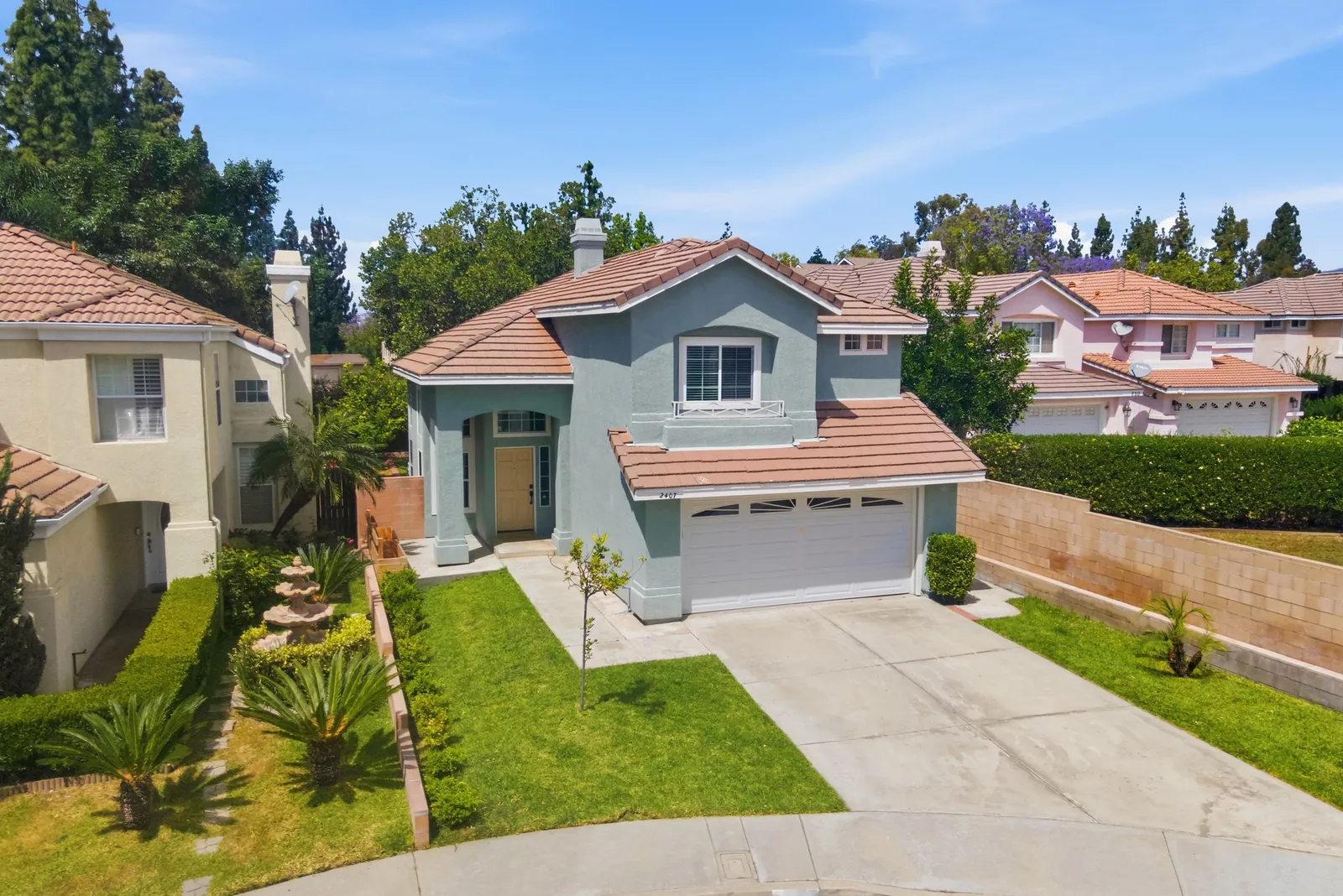 Two-story home with a red tile roof at the end of a cul-de-sac