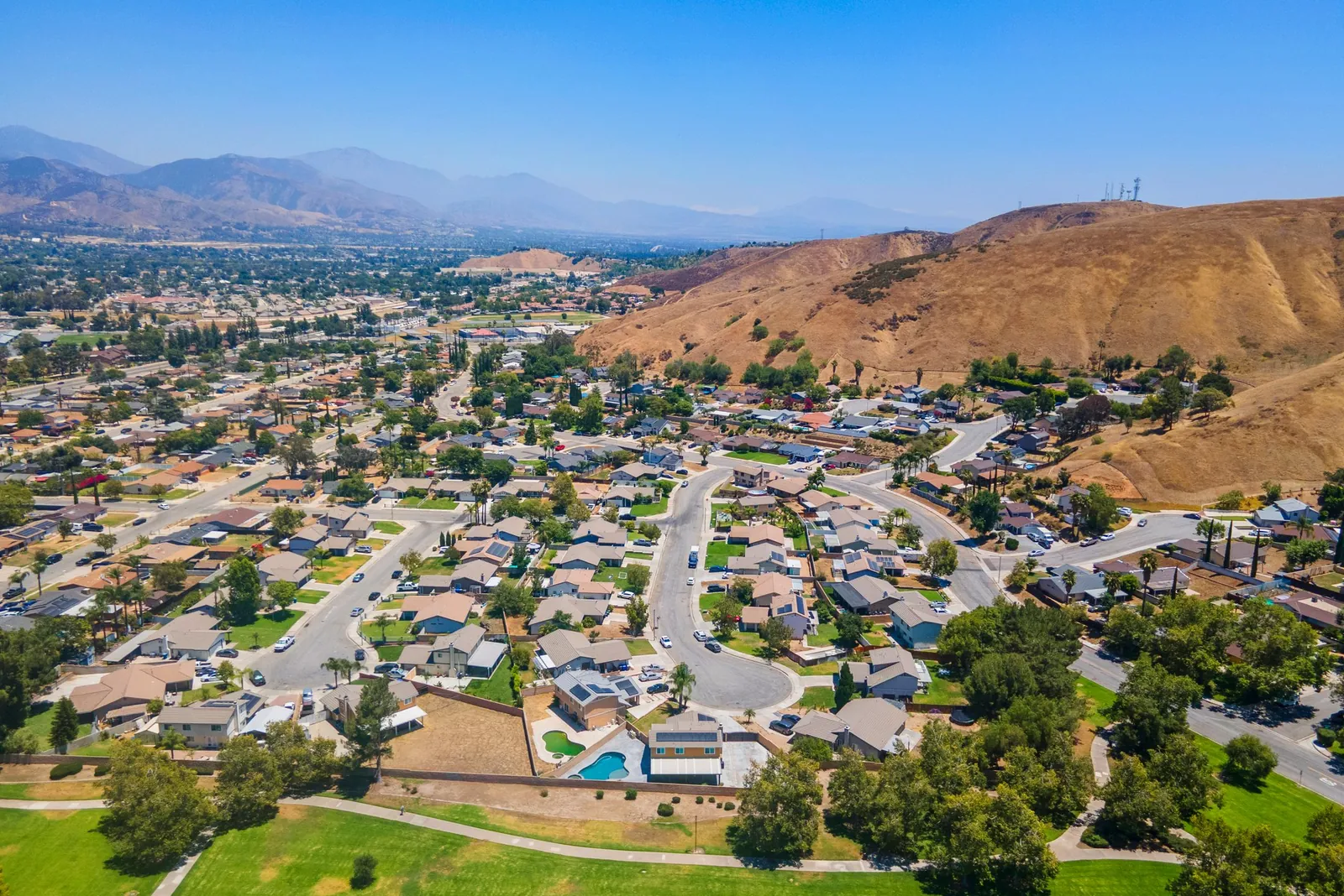 Aerial view of a San Bernardino neighborhood below dry hills and mountains